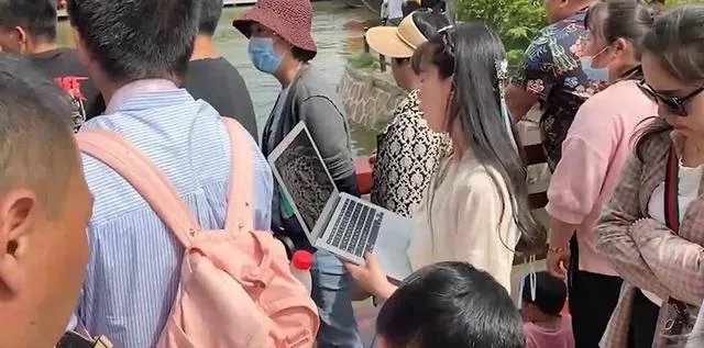 女子景区抱电脑边工作边游玩，具体情况是什么？